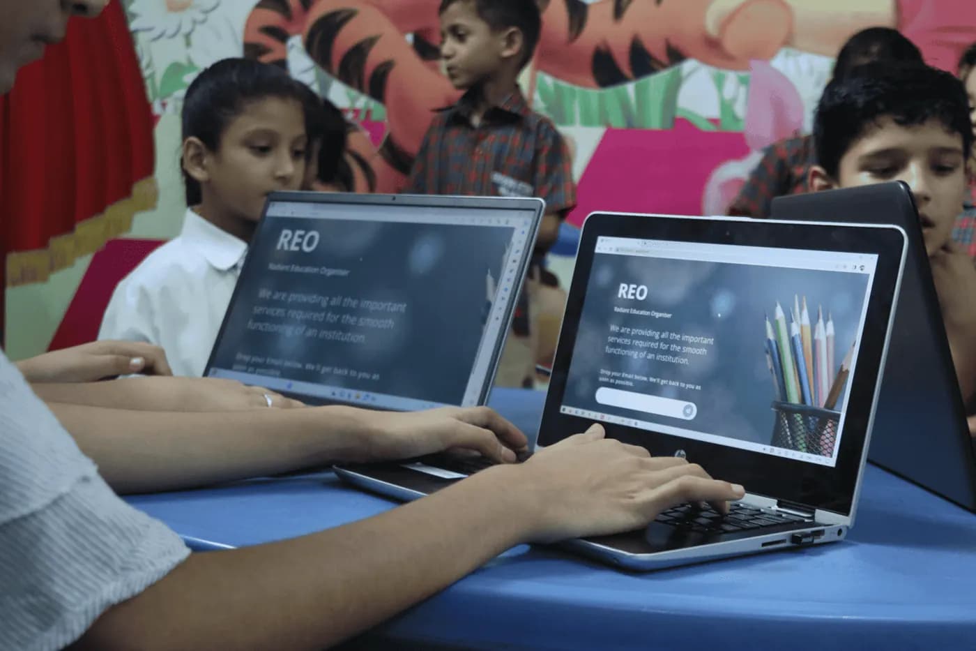 Pupils working on laptops in a colourful classroom